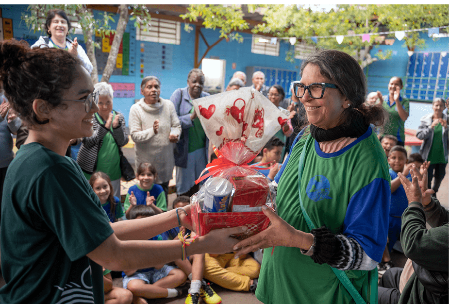 SAO CARLOS_SP 09 de Junho de 2025 OCB / ESCOLA EDUCATIVA  Na imagem, Helena Reis, aluna, da o premio a Sandra Botelho, vencedora do Bingo promovido pelos alunos da Escola Educativa. Alunos da Escola Educativa recebem idosos e criancas da instituicao Nave Sal da Terra, com lanche, atividades e brincadeiras.  Imagem: Alexandre Rezende / NITRO Historias Visuais