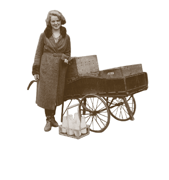 A woman is standing next to a cart with a wooden box on it. Description generated by AI