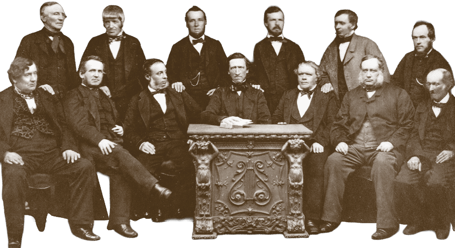 A group of men in suits sitting in front of a table. Description generated by AI