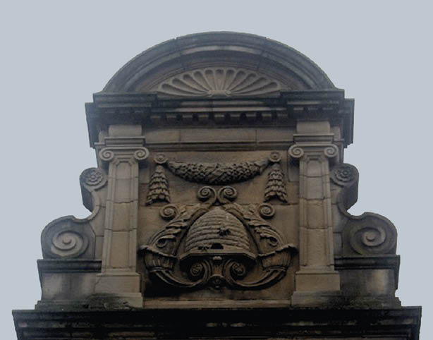 A stone building with a carved design of a bee. Description generated by AI