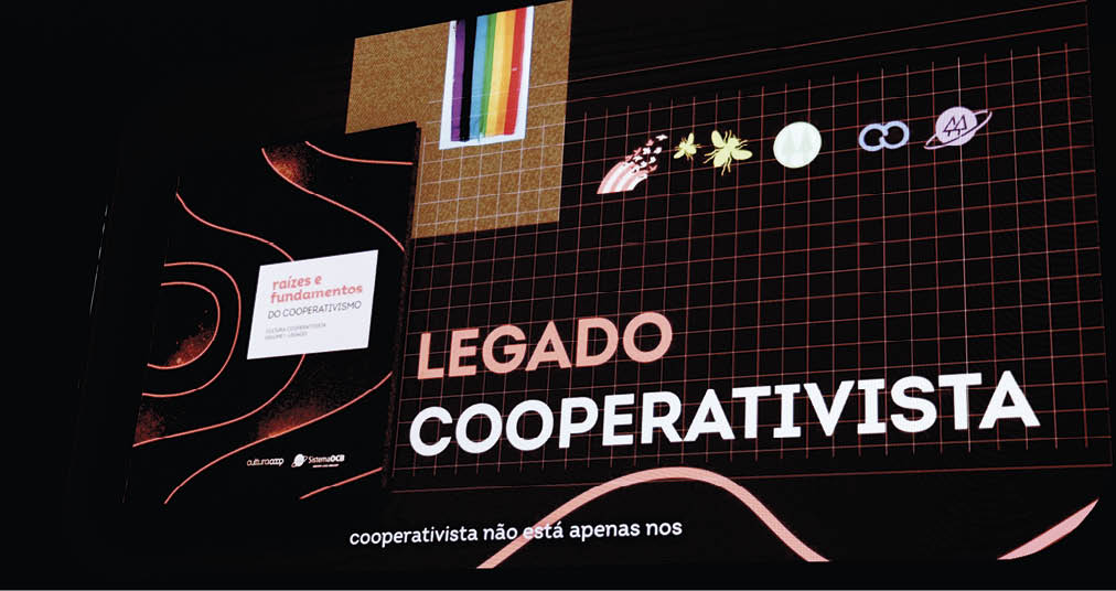 Painel com design moderno apresenta o texto “Legado Cooperativista" e elementos gr ficos coloridos sobre fundo escuro. Description generated by AI
