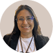 Pessoa adulta sorridente com cabelo longo, usando culos, camiseta branca e blazer preto, com fundo circular bege.  Description generated by AI